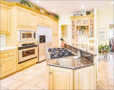  ?? Pearce Real Estate ?? The kitchen at 29 Cromwell Road in North Haven features custom cabinetry, an island with breakfast bar, stainless steel appliances, a butler’s pantry and a sunny dining area. The custom crafted home and carriage house are on more than 2 park-like acres.