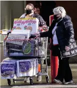  ??  ?? Trolley dash: Shoppers bulk-buying at Costco in Glasgow yesterday