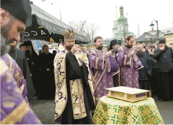  ?? ROMAN HRYTSYNA/AP ?? Priests of the Ukrainian Orthodox Church pray with their supporters Saturday after resisting a government order to vacate the famed Kyiv Pechersk Lavra monastery complex in Kyiv, which is Ukraine’s most revered Orthodox site.