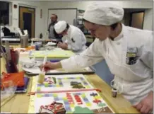 ?? THE ASSOCIATED PRESS ?? Students Allie Trojano, front, and Deron Noel, rear, work on dessert projects Jan. 26 during a class at the New England Culinary Institute in Montpelier, Vt. Enrollment in culinary institutes across the country is in decline and some cooking schools...