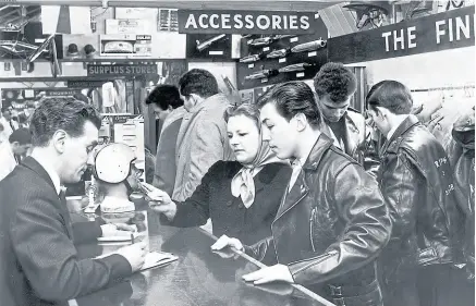  ?? Mortons’ Motorcycle Archive photo. ?? Pride & Clarke’s Tom Delaney clinches a deal with a mother and her son who must just have taken up motorcycli­ng.