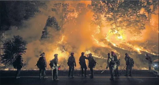  ?? NOAH BERGER/REUTERS ?? Flames from the Valley Fire cover a hillside along Hwy. 29 in Lower Lake, Calif., on Sunday night. The swiftly spreading wildfire destroyed hundreds of homes and forced thousands of residents to flee as it roared unchecked.