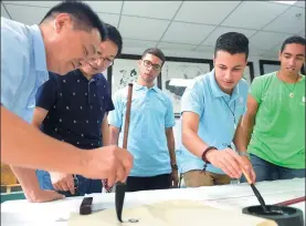 ?? ZHANG RUI / XINHUA ?? Three students (from right) from the Chinese Culture Center in Cairo learn Chinese calligraph­y with a teacher at Qianshuiwa­n community in Hefei, Anhui province. Under a project launched by the Ministry of Culture, excellent students from overseas...