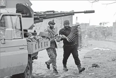  ?? KHALIL ASHAWI / REUTERS ?? Turkish-backed Free Syrian Army fighters hold an ammunition belt near the city of Afrin, Syria, on Wednesday.