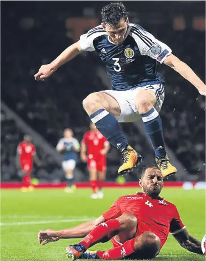  ?? Picture: SNS Group. ?? Andy Robertson hurdles a challenge from Malta’s Steve Borg.