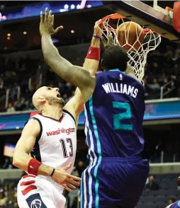  ??  ?? WASHINGTON WIZARDS center Marcin Gortat (left) dunks on Charlotte Hornets defender Marvin Williams during the fourth quarter of the Wizards’ 109-106 home victory on Wednesday night.