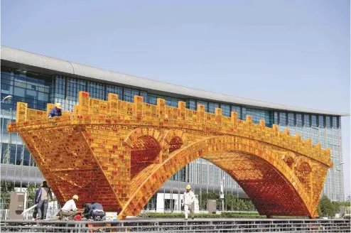  ?? PHOTOS ANDY WONG ASSOCIATED PRESS ?? L’oeuvre artistique Le pont d’or de la route de la soie a récemment été installée dans le parc olympique de Pékin. Cette oeuvre a été inspirée par le pont Zhaozhou, qui fut construit il y a 1400 ans dans le nord de la Chine et qui est toujours utilisé aujourd’hui.