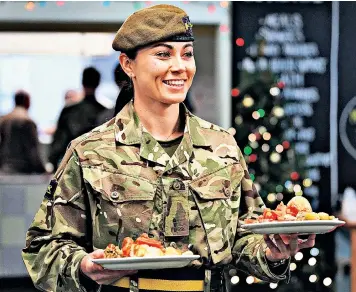  ?? ?? Private Ciara Lonergan of the 3rd Battalion Princess of Wales’s Royal Regiment helps out at a homeless centre in Canterbury, Kent