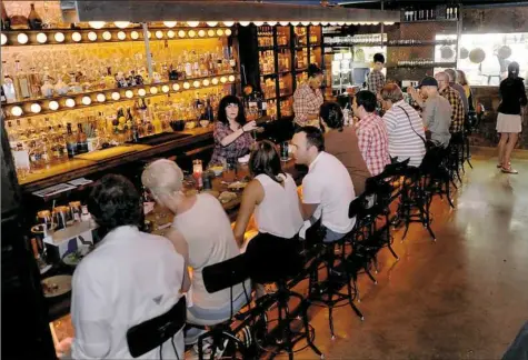  ?? Pam Panchak/Post-Gazette ?? Maggie Meskey, then the bar manager at Tako on Sixth Avenue Downtown, tends to a packed bar on June 12, 2015.