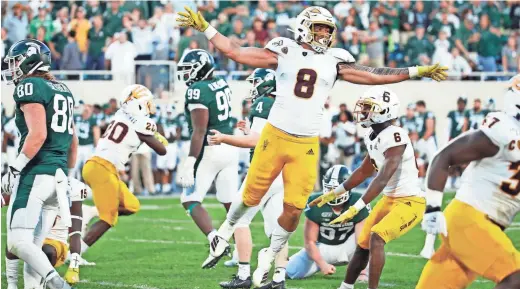  ?? GETTY IMAGES ?? Arizona State’s Merlin Robertson (8) celebrates after a missed field goal by No. 18 Michigan State as time expired to give the Sun Devils a 10-7 win. Michigan State’s Matt Coughlin had kicked a 42-yarder moments before, but it was called back because the Spartans had too many players on the field.