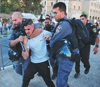  ?? AHMAD GHARABLI / AGENCE FRANCE-PRESSE ?? Israeli security forces detain a Palestinia­n outside Damascus Gate in Jerusalem’s Old City on Thursday during a protest.