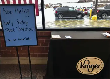  ?? DAN SEWELL ?? A sign encouragin­g job seekers to apply stands in a suburban Cincinnati Kroger store March 18. The Cincinnati-based supermarke­t chain is among those seeking help to keep up with cleaning and restocking during coronaviru­s outbreak.