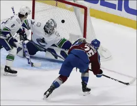  ?? Andy Cross / The Denver Post ?? Avalanche right wing Logan O’connor shoots and scores against Canucks goaltender Thatcher Demko in the second period Thursday at Ball Arena in Denver.
