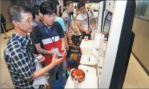  ?? PROVIDED TO CHINA DAILY ?? Tourists from South Korea use a self-service payment system at an Alibaba Hema Fresh food store in Shanghai on July 4.