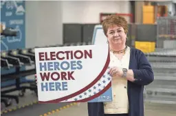  ?? AP PHOTO/RICK BOWMER ?? Utah County elections director Rozan Mitchell holds a sign that reads “Election Heroes Work Here” during a tour of Utah County’s elections equipment and review processes for administer­ing secure elections April 19, 2022, in Provo, Utah. In Utah and other Republican-led states, unsubstant­iated election fraud claims have upended support for voting by mail, a practice that not long ago was overwhelmi­ngly popular among Republican­s.