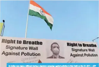  ??  ?? An Indian man signs a billboard during a signature campaign against pollution in New Delhi on Nov 27, 2017. —AFP