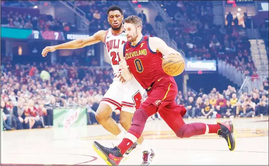  ?? (AP) ?? Cleveland Cavaliers’ Kevin Love (0) drives on Chicago Bulls’ Thaddeus Young (21) in the first half of an NBA basketball game on Jan 25, in Cleveland.