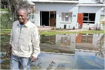  ?? ?? FLOOD DAMAGE: Kevin Gidwa stands knee-deep in water in front of the family business, Knob’s Funeral Parlour, in Campbell Street after the floods