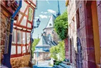  ?? Foto: Georg Kronenberg, Marburg Stadt und Land Tourismus GmbH, tmn ?? Fachwerk, Kirchturm, verwinkelt­e Gasse – ein typischer Ausschnitt Mar‰ burgs.