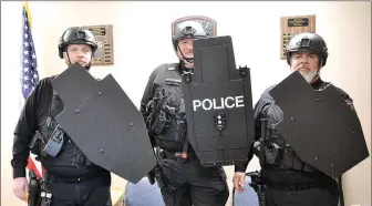  ?? Annette Beard/Pea Ridge TIMES ?? Pea Ridge Police officers Jamie Holland, Sgt. Todd Cornwell and Charles Snyder show some of the new gear — helmets and shields — recently purchased by the Pea Ridge Police Department.