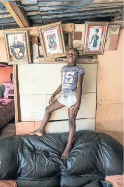  ??  ?? Sigidi Yakhanani stands proudly in front of her school certificat­es in her family’s home on the upper slopes of Imizamo Yethu.