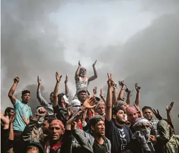  ?? Foto: Wissam Nassar, dpa ?? Ein Bild wie ein Schlachten­gemälde. Palästinen­sische Demonstran­ten vor einer Wand aus Rauch. Um der israelisch­en Armee die Sicht zu nehmen, hat die Hamas tausende von Reifen angezündet.