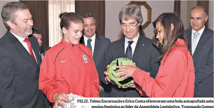  ??  ?? FELIZ. Telma Encarnação e Erica Costa ofereceram uma bola autografad­a pela equipa feminina ao líder da Assembleia Legislativ­a, Tranquada Gomes