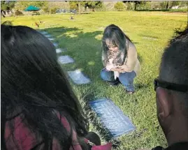  ??  ?? LISA HA Nishihara visits Tran Thi Nam’s grave in Oceanside. She thinks her great-grandmothe­r would have lived longer had the family not left Vietnam.