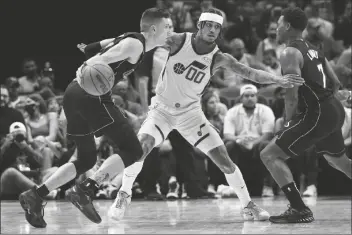  ?? LYNNE SLADKY/AP ?? MIAMI HEAT GUARD TYLER HERRO (left) drives to the basket as Utah Jazz guard Jordan Clarkson (00) defends during the first half of a game, Saturday in Miami.