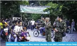  ?? — AFP ?? MAGUINDANA­O, Philippine­s: Moro Islamic Liberation Front (MILF) members secure Camp Darapanan in Sultan Kudarat on the southern island of Mindanao yesterday.