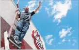  ?? CLIFFORD SKARSTEDT/EXAMINER ?? Camille Parent waves atop Arby’s on Thursday on Lansdowne St. W. Parent is on the roof on Friday and Saturday.