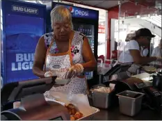  ??  ?? Sandra Dailey, left, owner of Sandi’s Soul Food, dishes up her seafood gumbo at Levi’s Stadium in Santa Clara.