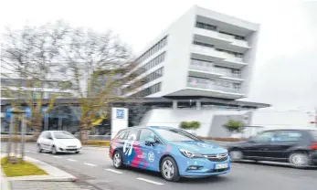  ?? ARCHIV-FOTO: DPA/FELIX KÄSTLE ?? Ein Versuchsfa­hrzeug für automatisi­ertes Fahren fährt am ZF-Forum vorbei. In der Regel sind die Autos aber nicht beklebt und von außen schwer zu erkennen.