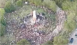  ?? PROVIDED PHOTO ?? Hundreds of protesters surround the Christophe­r Columbus statue in Grant Park on Friday night.