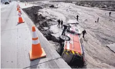  ?? DAVID PARDO/THE DAILY PRESS ?? In February, officials look over the scene at Interstate 15 in the Cajon Pass, Calif., where part of the freeway collapsed due to heavy rain. A state plan raises fuel taxes and fees to pay for repairs to roads.