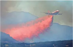  ?? KENT PORTER/THE PRESS DEMOCRAT VIA AP ?? A 747 Global air tanker drops retardant Friday on a fire in Scotts Valley near Lakeport, Calif.