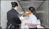  ?? ASTRID GALVAN/THE ASSOCIATED PRESS ?? U.S. Customs and Border Protection officer Rachel McCormick, left, and Mexican customs officer Alejandra Galindo demonstrat­e cargo inspection at the Mariposa Inspection Facility at the Nogales Port of Entry in Arizona.