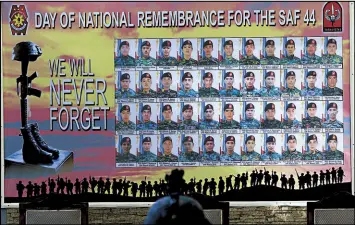  ?? EDD GUMBAN ?? A police commando at Camp Bagong Diwa in Taguig looks at a tarpaulin honoring the SAF 44 during the third anniversar­y of the Mamasapano raid yesterday.