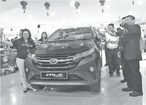  ??  ?? PETER Ngu (kanan) bersama Esther Kong (kiri) serta yang lain pada majlis pelancaran Perodua Aruz, malam kelmarin.