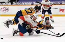  ?? CHRISTOPHE­R HANEWINCKE­L/USA TODAY SPORTS ?? Florida Panthers center Carter Verhaeghe (23) misses on a shot attempt as he is hit by Nashville Predators right wing Rocco Grimaldi (23) during the second period Saturday at Bridgeston­e Arena.