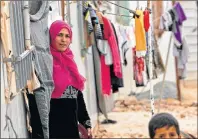  ?? AP PHOTO ?? Syrian refugees stand outside during a visit by UN refugee chief Filippo Grandi to the Zaatari Syrian Refugee Camp, in Mafraq, Jordan on Monday. Grandi said the number of Syrian refugees deported from Jordan to their war-ravaged homeland has “decreased...