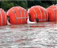  ?? ?? Un migrante se encuentra con la barrera de boyas flotantes mientras busca cruzar el Río Bravo en Eagle Pass, Texas.