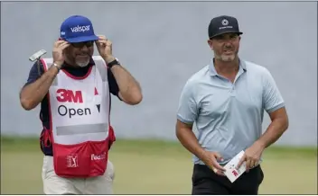  ?? ABBIE PARR — THE ASSOCIATED PRESS ?? Scott Piercy, right, and his caddie walk up onto the 14th green during the second round of the 3M Open golf tournament at the Tournament Players Club in Blaine, Minn. on Friday.