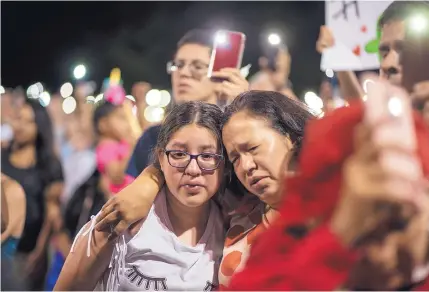  ?? ROBERTO E. ROSALES/JOURNAL ?? Nora Martinez, right, and her 11-year-old daughter grieve during a candleligh­t vigil at Ponder Park on Sunday in El Paso. It was held in honor of the victims of Saturday morning’s mass shooting.