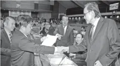  ??  ?? Dr Edwin Bosi with SriTanjung assemblyma­n Chan Foong Hin handing over a document on pygmy elephants to Datuk Masidi Manjun before the Assembly sitting started.