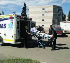  ?? CAILYNN KLINGBEIL/EDMONTON JOURNAL ?? A suspect in a fatal hit and run, wrapped in a white sheet, is loaded into an ambulance, Monday following a police chase.