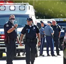  ??  ?? GATHERING: Police officers who responded to the scene of Thursday’s stabbing confer outside the home of Steven Sossong.