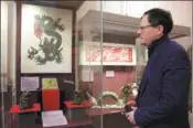  ?? IRINA MOTINA / XINHUA ?? A man views Chinese dragon-themed items at the State Museum of the History of Religion in St. Petersburg, Russia, on Jan 19.