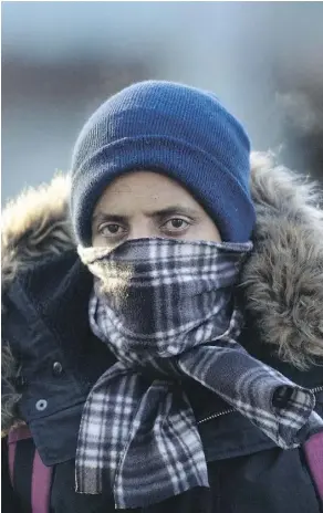  ?? DAVID BLOOM ?? A pedestrian bundles up with a scarf near Jasper Avenue at 101 Street on Thursday.