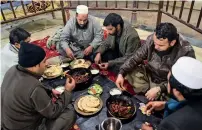  ?? AFP ?? A cook fries kebabs while customers look on at the Tory Kebab House in Namak Mandi in Peshawar; and, right, customers eat grilled meat at the Charsi (Hashish) Tikka restaurant. —